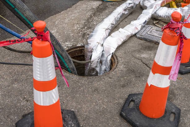 City construction project with water suctions hoses at street manhole