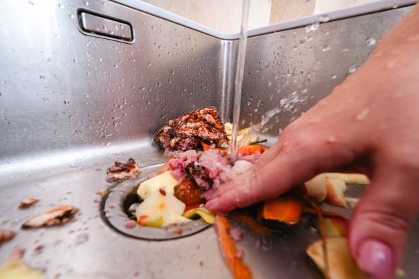 Removing food scraps with running water and garbage disposer in a kitchen sink